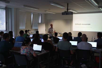 [Translate to English:] A man stands in front of an audience and gives a presentation.
