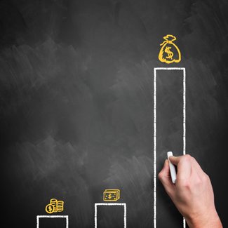 An der Tafel wird mit Kreide Gehälterverteilung erklärt.