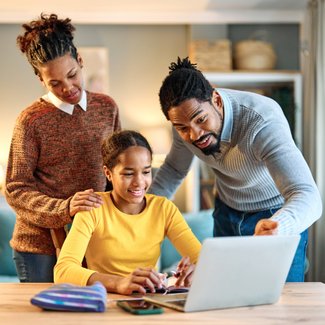 Eltern helfen ihrer Tochter bei den Hausaufgaben