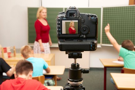 Bild einer digitalen Kamera, die eine Leherin im Klassenzimmer aufnimmt