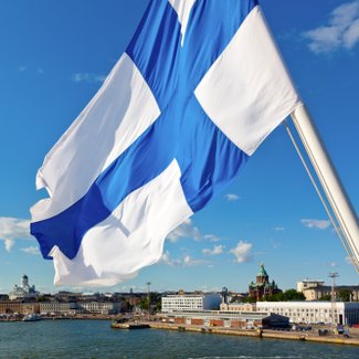 Finnische Flagge vor dem Panorama von Helsinki