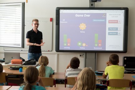 Bild von einem Lehrer, der die Ergebnisse von einem Kahoot-Spiel mit seiner Klasse bespricht